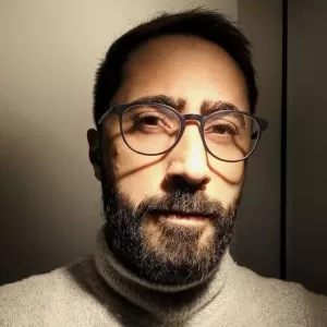 Psicólogo André Veridiano, profissional sério com óculos e fundo neutro