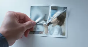 Homem rasgando fotografia representando adultização infantil